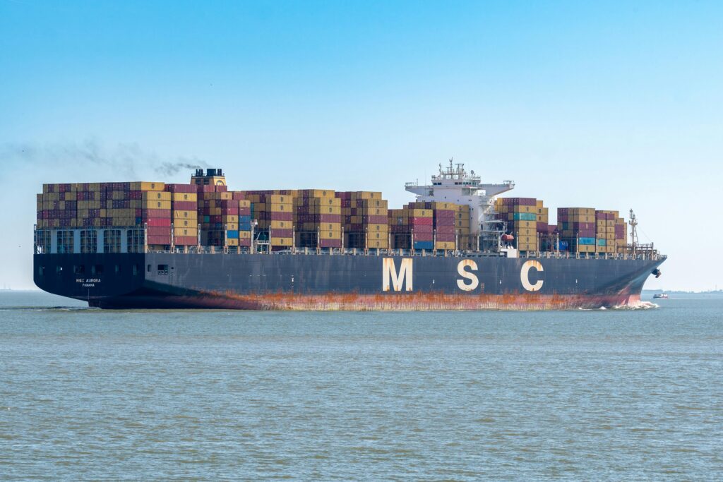 pexels-photo-27961514-27961514 MSC container ship transporting cargo on open sea under clear sky.