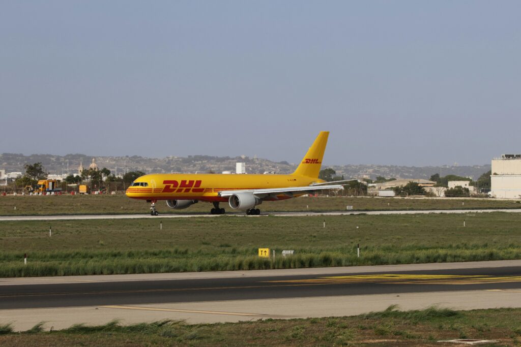 pexels-photo-29358895-29358895 DHL cargo plane preparing for takeoff on a sunny runway, showcasing logistics and aviation.