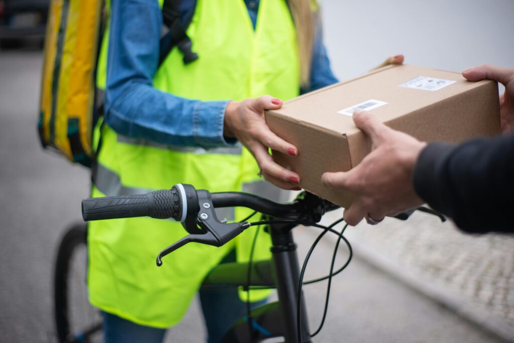 pexels-photo-7843932-7843932 Bicycle courier handing over a package outdoors in Portugal.